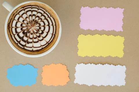 A cup of latte art and note paper on brown paper background Stock Photos