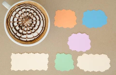 A cup of latte art and note paper on brown paper background Foto stock