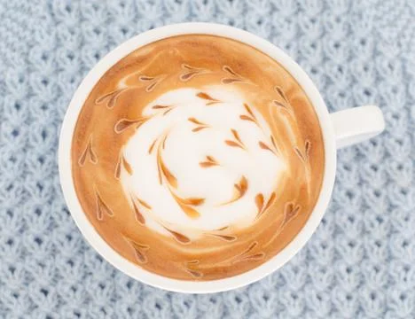 A cup of latte art on a knitted  background Stock Photos