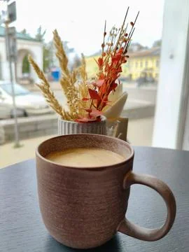A cup of latte in a ceramic mug on a table in a cafe Stock Photos