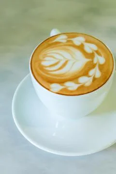 A cup of latte is on the marble table. Stock Photos