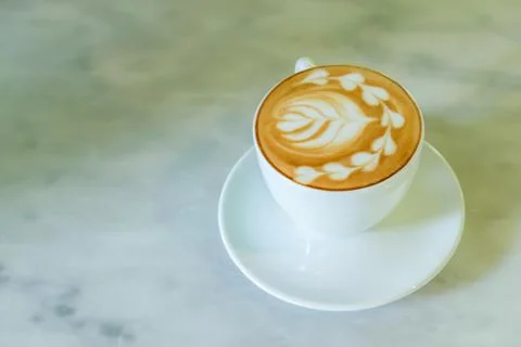 A cup of latte is on the marble table. Stock Photos