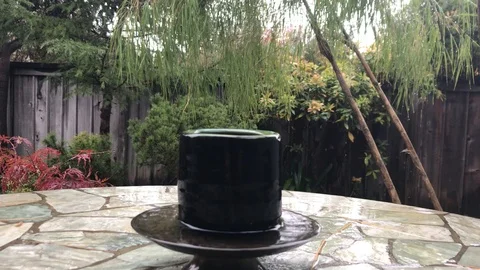 Cup left out on the table in the rain Stock Footage 99017937