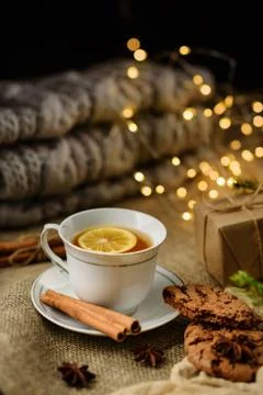 A cup of lemon tea with selective focus on the table with cinnamon, gift box Stock Photos