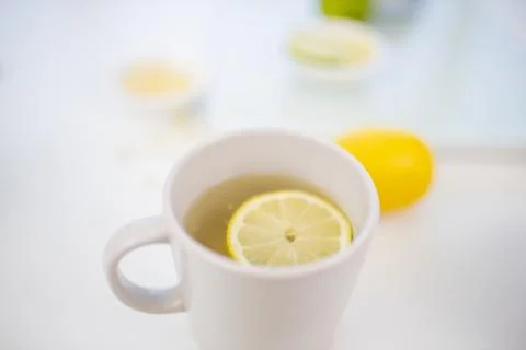 Cup of lemon tea on a table with limes and lemons Stock Photos