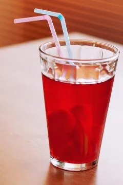 Cup of lemonade with two colored straws Stock Photos