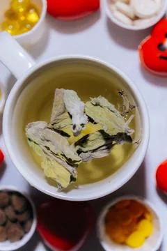 A cup of light peppermint herbal tea with dried leaves. Stock Photos