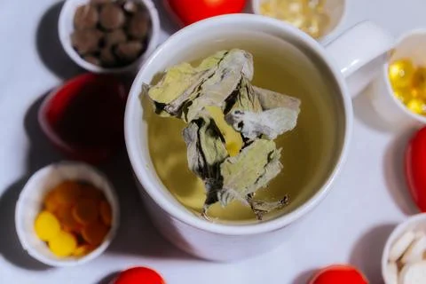 A cup of light peppermint herbal tea with dried leaves. Stock Photos