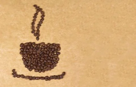 Cup made of coffee beans on baking parchment Stock Photos