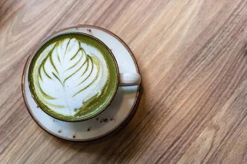 A cup of match latte on the table. Late art on a green background Stock Photos
