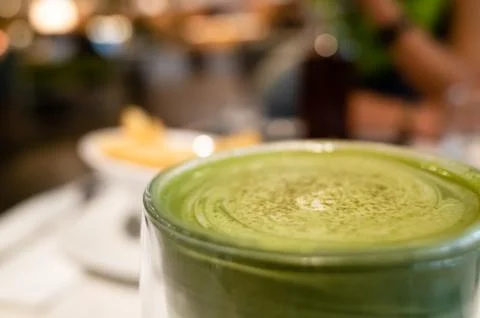 Cup of matcha milk tea on table Stock Photos