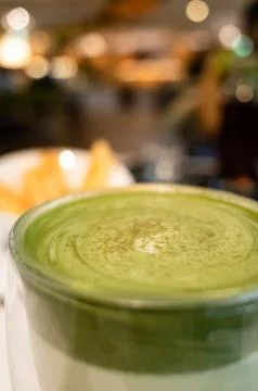 Cup of matcha milk tea on table Stock Photos