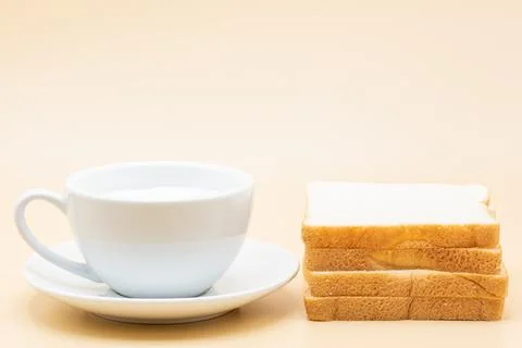 A cup of milk and a bread Stock Photos