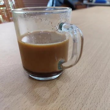 A cup of milk coffee on the table Stock Photos