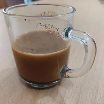 A cup of milk coffee on the table Stock Photos