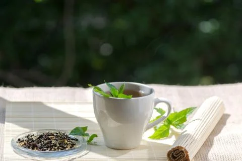 Cup of mint tea and a bunch of mint on the table Stock Photos