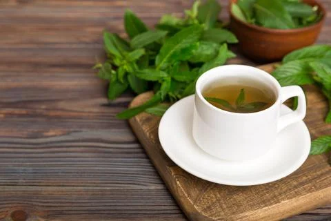Cup of mint tea on table background. Green tea with fresh mint top view with  Stock Photos