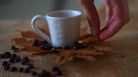 Cup mug of coffee in fall leaves with beans and pretzels Stock-Footage 94290848