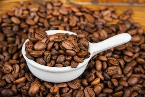 Cup od coffe with roasted bean on the wooden table. Stock Photos