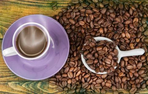 Cup od coffe with roasted bean on the wooden table. Stock Photos