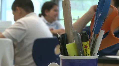 A cup with pens, a ruler and scissors with students in back ground  (2 of 2) Stock Footage 8978918