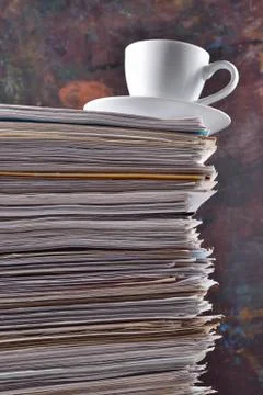 Cup on a pile of papers Stock Photos
