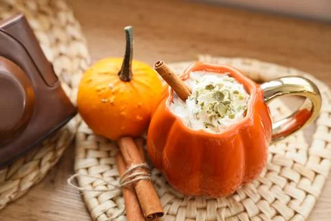 Cup of pumpkin latte with camera and cinnamon on table at home, closeup Stock Photos