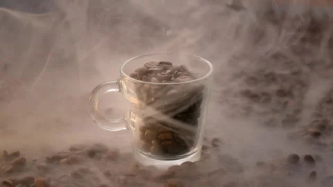 Cup of raw coffee brown background moving smoke 4k closeup Stock Footage 270175739