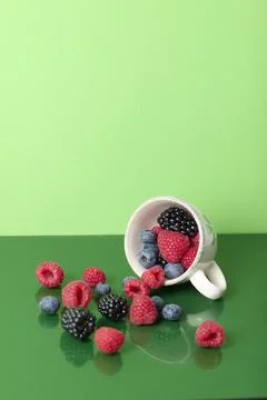 Cup with red fruits on green background Stock Photos