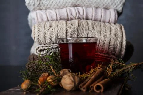 Cup with red tea on a decorated desk and sweaters in the background at home  Stock Photos
