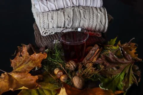 Cup with red tea on a decorated desk with leaves and nuts at home Stock Photos