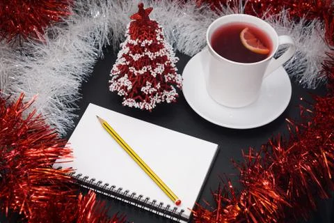Cup of red tea with lemon slice, notebook with pencil, red and white christma Stock Photos