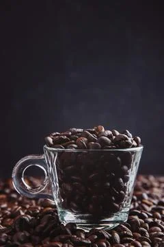 Cup with roasted coffee beans. Close up shot. cups on  table with scattered.. Stock Photos