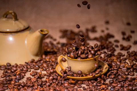 Cup with roasted flying coffee beans Stock Photos