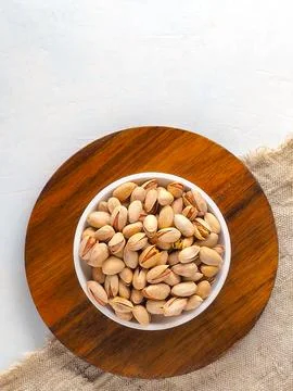 Cup with selected in-shell pistachios on light background with copy space Stock Photos