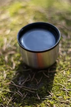 Cup with sky reflection - picnic on mossy rock Stock Photos