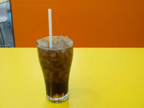 A cup of soft drink on the yellow table Stock-Fotos