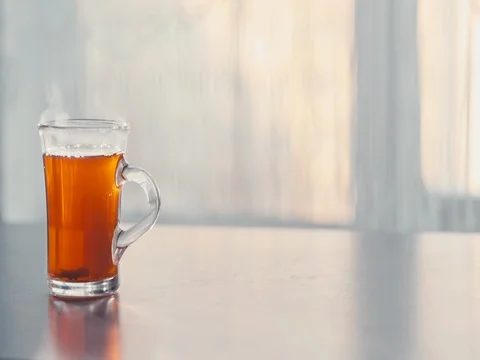 A Cup of steaming hot tea on the table against the window. 動画素材 73980419