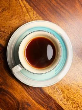 A cup of streaming hot tea served in a ceramic cyan-and-white tea set Stock-Fotos