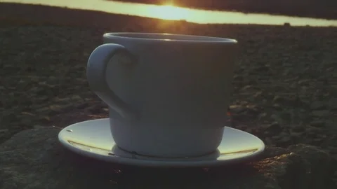 A cup of tasty and invigorating tea or coffee on a stone in the rays of the Stock Footage 80859517
