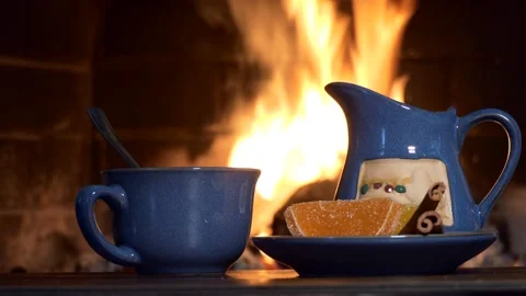A Cup of tea, accessories and sweets for tea on the background of the fireplace. Vídeos de archivo 145255214