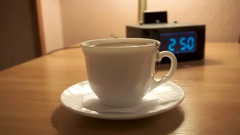 A Cup of tea and a digital watch, alarm Stock Footage 103388470