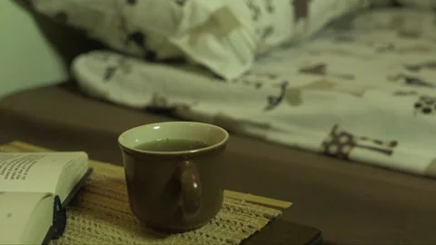 Cup of tea and an open book in the bedroom Stock Footage 237782821