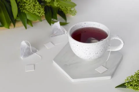 Cup with tea and set of triangle infusion tea bag with tag. Stock Photos