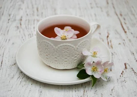 Cup of tea and spring apricot blossom on a wooden background Stock Photos