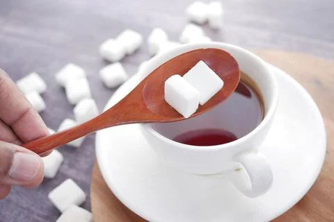 Cup of tea and sugar cube on table Stock Photos