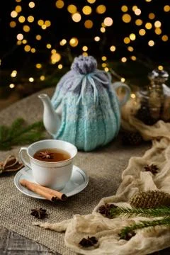 A cup of tea and a teapot on the table with cinnamon sticks, star anise, Chri Stock Photos