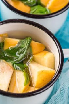 Cup of tea with apples and basil Stock Photos