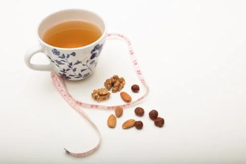 Cup of tea with assorted dried nuts and tape Stock Photos