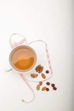 Cup of tea with assorted dried nuts and tape Stock Photos